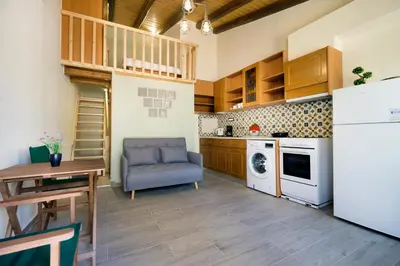 a kitchen with a table and a chair and a refrigerator at Kyriaki's Traditional Loft in Galatás