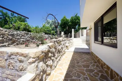 a stone retaining wall next to a building at Kyriaki's Traditional Loft in Galatás