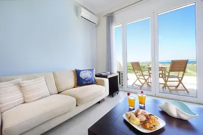 a living room with a couch and a plate of food on a table at Geas House Thalassa in Kolymvari