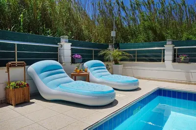 a pool with two lounge chairs and a swimming pool at Geas House Thalassa in Kolymvari
