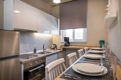 a kitchen with a table with white plates on it at Sun Ray Luxury Apartments in Agia Marina Nea Kydonias
