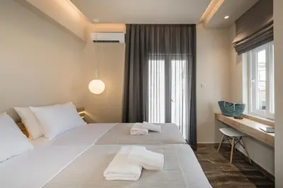 a bedroom with a large white bed with towels on it at Sun Ray Luxury Apartments in Agia Marina Nea Kydonias