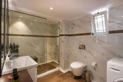 a bathroom with a shower and a sink and a toilet at Sun Ray Luxury Apartments in Agia Marina Nea Kydonias