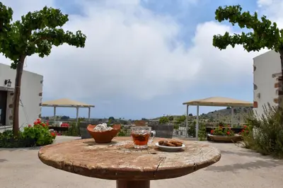 a wooden table with a drink and food on it at Madares Apartments Anopolis in Anopoli Sfakion