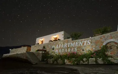 a building with a sign on the side of it at night at Madares Apartments Anopolis in Anopoli Sfakion