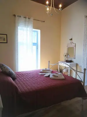 a bedroom with a bed with a red blanket and a window at Apollon Hotel in Chania Town