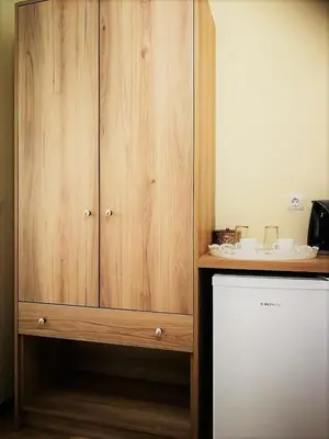 a wooden cabinet in a kitchen next to a refrigerator at Apollon Hotel in Chania Town