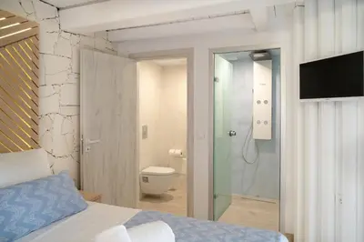 a bedroom with a bed and a shower and a toilet at Nine in Chania Town