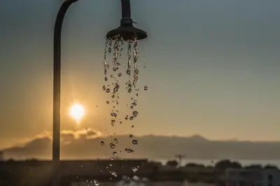 a drop of water hanging from a street light at Christiana Apartments in Gerani Chanion