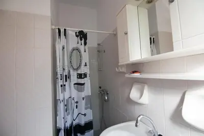 a white bathroom with a shower and a sink at Christiana Apartments in Gerani Chanion
