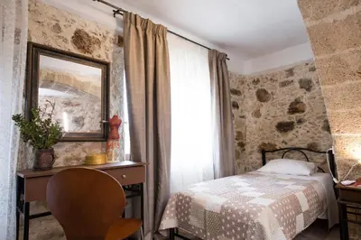 a bedroom with a bed and a mirror and a chair at Μylos in Kissamos