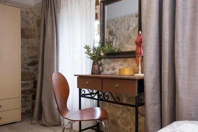 a bedroom with a desk and a chair and a mirror at Μylos in Kissamos