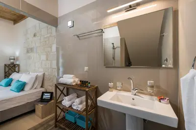 a bathroom with a sink and a bed at Villa Rebecca in Agia Marina Nea Kydonias