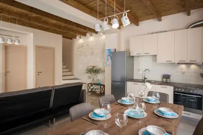 a kitchen with a wooden table with glasses on it at Villa Rebecca in Agia Marina Nea Kydonias