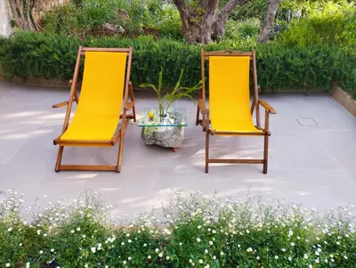 two chairs with yellow cushions sitting on a patio at Olive Lemon Biophilic House & Lush Forest Garden in Vamos