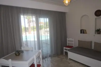 a living room with a bed and a table and a window at Maria Suites in Plataniás