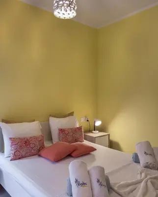 a bedroom with a bed with white sheets and pillows at Alisahni Villa & Suite in Kato Daratso