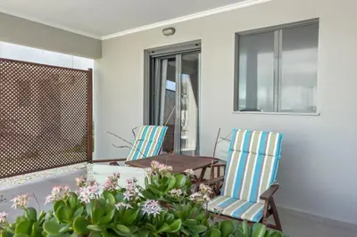 a balcony with a table and chairs and flowers at Alisahni Villa & Suite in Kato Daratso