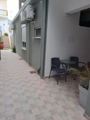 a patio with chairs and a table in a building at Parthenon Hotel in Souda