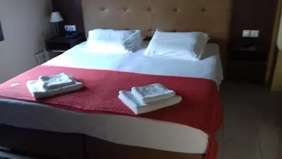 a hotel room with a bed with towels on it at Parthenon Hotel in Souda