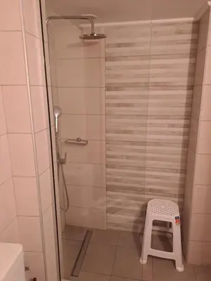 a shower with a stool in a bathroom at Parthenon Hotel in Souda
