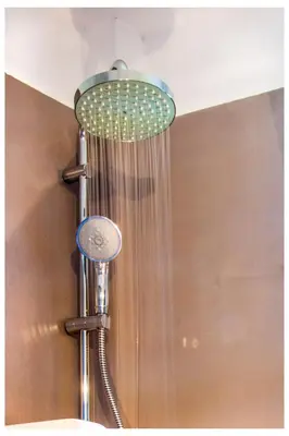 a shower with a shower head on a wall at Tree of Life Art Hotel in Agia Marina Nea Kydonias