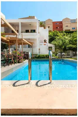 a swimming pool with two silver poles next to a building at Tree of Life Art Hotel in Agia Marina Nea Kydonias