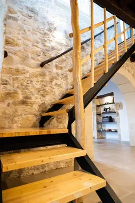 a wooden staircase in a building with a stone wall at Traditional Villa in fres in Frés