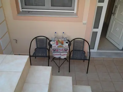 a table with two chairs and a plate of food at father's house in kissamos in Korfalónas
