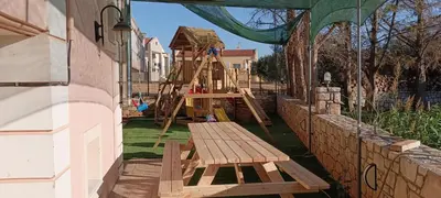 a playground with a wooden slide and a wooden table at father's house in kissamos in Korfalónas