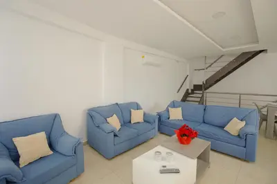 a living room with two blue couches and a table at Villa Martini in Kissamos