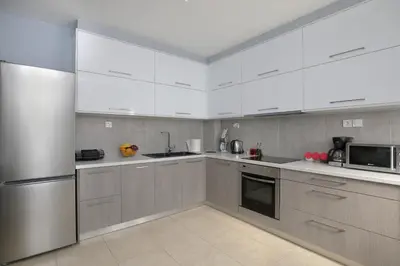 a kitchen with white cabinets and stainless steel appliances at Villa Martini in Kissamos