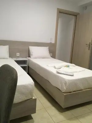 a bedroom with two beds and a door to another room at Villa Martini in Kissamos