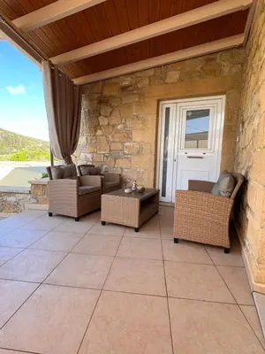 a patio with couches and a table and a door at Villa Martini in Kissamos