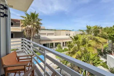 a balcony with a table and chairs and palm trees at Alisahni Home 1 in Kato Daratso