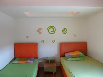 two beds in a room with green and orange at Penthouse in Chania Town