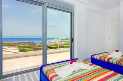 two beds in a room with a view of the ocean at Luxury Villa Stella with private swimming pool in Tersanas
