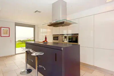 a large kitchen with a black counter top and a stove at Luxury Villa Stella with private swimming pool in Tersanas