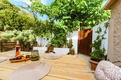 a wooden table with glasses of wine on a patio at Anna's Village House in Perivólia