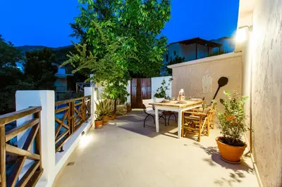 a patio with a table and chairs on a balcony at Anna's Village House in Perivólia