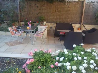 a patio with a table and chairs and flowers at Nicolas Studios & Apartments in Agia Marina Nea Kydonias