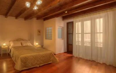 a bedroom with a bed and a large window at Palazzo Duca in Chania Town