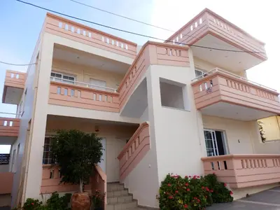 a house with balconies and flowers in front of it at Babis Apartments in Plataniás