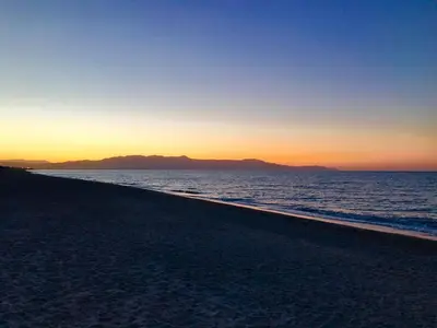 a view of the beach at sunset at Katerina Seaside Studios in Plataniás
