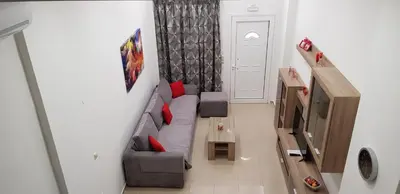 a living room with a gray couch and red pillows at Rodoula Luxury Apartment 1 in Chania Town