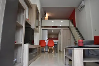 a living room with a staircase and red chairs at Rodoula Luxury Apartment 1 in Chania Town