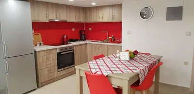 a small kitchen with a table and red walls at Rodoula Luxury Αpartment 2 in Chania Town