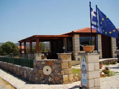 a building with a flag in front of it at Drapanias BeachFront Apartments - Marinakis in Kissamos