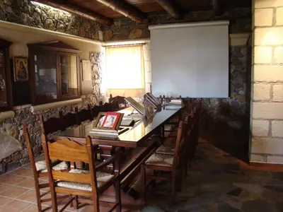 a room with a long table with chairs and a screen at Drapanias BeachFront Apartments - Marinakis in Kissamos