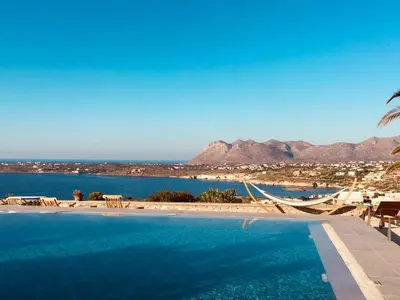 a swimming pool with a view of the ocean and mountains at Theodosia Studios in Kalathas